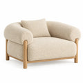 Curved beige and brown armchair from ArchitraveandAbacus, showcasing a stylish design with smooth lines and plush upholstery.